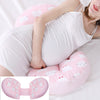 a pregnant woman laying on a pregnancy pillow